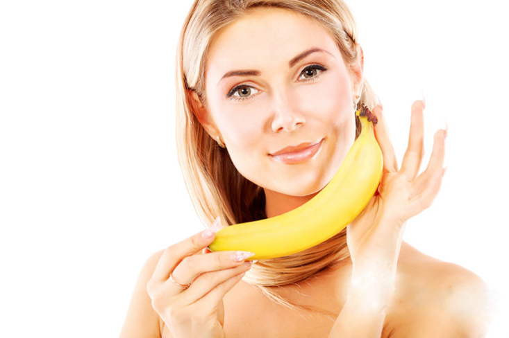 Portrait of a beautiful young woman holding bananas.